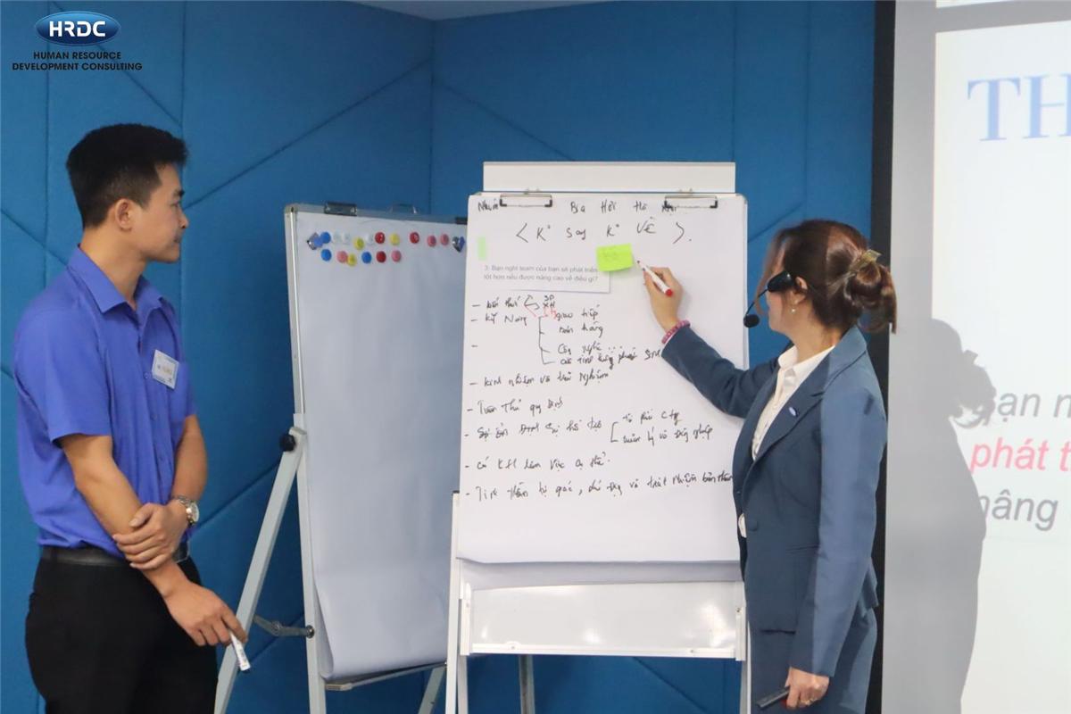 Giảng viên HRDC hướng dẫn học viên trên flipchart