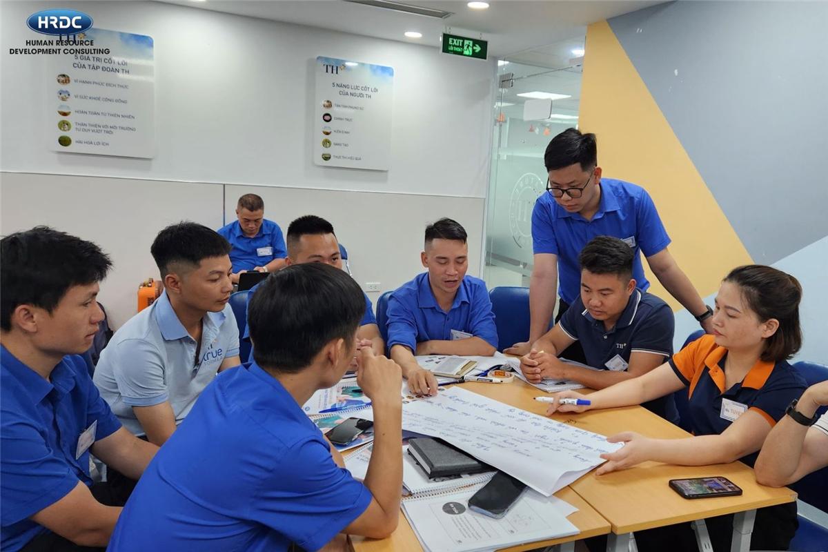 Nhóm học viên thảo luận trên bàn với tài liệu